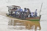 Pengendara sepeda motor dan warga menyeberangi Sungai Batanghari menggunakan perahu dari Desa Keranggan menuju Desa Berembang di Sekernan, Muaro Jambi, Jambi, Senin (20/10/2025). Warga setempat menyebutkan, sedikitnya 200 warga Sekernan yang berada di tepi Daerah Aliran Sungai (DAS) Batanghari masih menggunakan perahu untuk menyeberangi sungai terpanjang di Sumatera itu setiap harinya dengan tarif umum Rp7 ribu per motor pulang-pergi (PP) dan Rp5 ribu per motor PP untuk pelajar karena tidak adanya jembatan penghubung. ANTARA FOTO/Wahdi Septiawan/YU