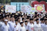 Sejumlah santri membawa poster saat mengikuti Apel Hari Santri di Taman Elektrik, Kota Tangerang, Banten, Rabu (22/10/2025). Apel yang dilaksanakan dalam rangka memperingati Hari Santri Nasional 2025 tersebut bertema Mengawal Indonesia Merdeka, Menuju Peradaban Dunia yang diikuti ribuan santri dari berbagai pesantren dan perguruan Islam. ANTARA FOTO/Putra M. Akbar/gp
