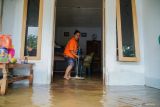 Warga membersihkan rumah terdampak banjir di Desa Sidorejo, Kecamatan Rowokangkung, Lumajang, Jawa Timur, Sabtu (25/10/2025). Sedikitnya 400 kepala keluarga terdampak banjir setinggi 50-90 sentimeter akibat luapan Sungai Banter setelah hujan deras mengguyur wilayah setempat. ANTARA Jatim/Irfan Sumanjaya/mas.
