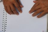 Seorang penyandang tunanetra membaca Al Quran braille bersama-sama saat Festival Tunanetra Mengaji di Monumen Kapal Selam (Monkasel), Surabaya, Jawa Timur, Sabtu (25/10/2025). Kawan Netra menggelar Festival Tunanetra Mengaji yang berisi sejumlah kegiatan di antaranya lomba ceramah, lomba cerdas cermat dan membaca Al Quran braille bersama yang diikuti oleh puluhan penyandang tunanetra dari Surabaya dan Sidoarjo. Antara Jatim/Didik Suhartono/um