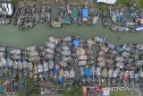 Foto udara perahu nelayan bersandar di muara sungai Limbangan,  Juntinyuat, Indramayu, Jawa Barat, Selasa (28/10/2025). Nelayan setempat mengaku sudah tidak melaut sejak seminggu terakhir akibat cuaca buruk berupa gelombang tinggi dan angin kencang di perairan Laut Jawa. ANTARA FOTO/Dedhez Anggara/agr