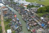 Foto udara perahu nelayan bersandar di muara sungai Limbangan,  Juntinyuat, Indramayu, Jawa Barat, Selasa (28/10/2025). Nelayan setempat mengaku sudah tidak melaut sejak seminggu terakhir akibat cuaca buruk berupa gelombang tinggi dan angin kencang di perairan Laut Jawa. ANTARA FOTO/Dedhez Anggara/agr