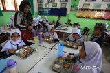 Sejumlah siswa menyantap Makanan Bergizi Gratis (MBG)  di Sekolah Dasar Negeri 20 Banda Aceh, Aceh, Kamis (30/10/2025). Badan Gizi Nasional (BGN) menegaskan batasan kapasitas porsi makanan harian  yang disiapkan setiap Satuan Pelayanan Pemenuhan Gizi  (SPPG)  dalam program Makanan Bergizi Gratis (MBG) maksimal sebanyak 3.000 porsi per hari dengan syarat memiliki tenaga juru masak yang kompeten dan bersertifikat BNSP. ANTARA FOTO/Ampelsa.