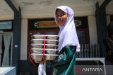 Seorang siswa membawa  nampan berisi menu Makanan Bergizi Gratis (MBG)  di Sekolah Dasar Negeri 20 Banda Aceh, Aceh, Kamis (30/10/2025). Badan Gizi Nasional (BGN) menegaskan batasan kapasitas porsi makanan harian  yang disiapkan setiap Satuan Pelayanan Pemenuhan Gizi  (SPPG)  dalam program Makanan Bergizi Gratis (MBG) maksimal sebanyak 3.000 porsi per hari dengan syarat SPPG memiliki tenaga juru masak yang kompeten dan bersertifikat dariBNSP. ANTARA FOTO/Ampelsa.