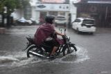 Pengendara motor melintasi genangan air di Jalan Tegalsari, Surabaya, Jawa Timur, Rabu (29/10/2025). Hujan deras yang mengguyur sekitar 2,5 jam mengakibatkan sejumlah ruas jalan di Surabaya tergenang air. ANTARA Jatim/Didik Suhartono/mas.