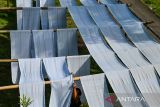 Pekerja mengeringkan kain untuk dijadikan kain pel yang telah selesai di produksi di Desa Laksana, Kecamatan Ibun, Kabupaten Bandung, Jawa Barat, Kamis (30/10/2025). Pekerja menyebutkan pada musim penghujan, produksi kain pel yang dijual dengan harga Rp50.000 per kodi tersebut mengalami penurunan hingga 50 persen atau hanya mampu memproduksi 150 kodi per minggu dibandingkan dengan musim kemarau yang mampu menembus hingga 300 kodi per minggu. ANTARA FOTO/Raisan Al Farisi/agr