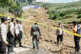 Petugas meninjau kondisi longsor yang menutup akses jalan arteri di Desa Kradinan, Tulungagung, Jawa Timur, Sabtu (1/11/2025). Lereng dengan kemiringan 45 derajat yang dimanfaatkan untuk ladang jagung itu longsor pada Jumat (31/10/2025) sore dan menyebabkan akses jalur Selingkar Wilis Tulungagung-Trenggalek putus total tertutup material longsoran. ANTARA Jatim/Destyan Sujarwoko/mas.