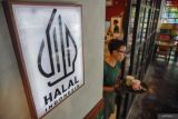 Percepatan sertifikasi halal untuk UMKM. Pramusaji mengantarkan makanan kepada pelanggan di Kedai Kopitiam, Lumajang, Jawa Timur, Minggu (19/10/2025). Badan Penyelenggara Jaminan Produk Halal (BPJPH) mempermudah sertifikasi halal bagi warung makan kecil melalui Program Sertifikasi Halal Gratis (Sehati) guna mendorong pelaku usaha mikro, kecil, dan menengah sebagai bagian dari percepatan menuju kewajiban sertifikasi halal bagi seluruh produk makanan dan minuman pada tahun 2026. Antara Jatim/Irfan Sumanjaya/um