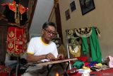 Perajin menyulam pernik kostum tari topeng tradisional di Galeri Setyotomo, Desa Glagah Dowo, Tumpang, Malang, Jawa Timur, Sabtu (1/11/2025). Setiap bulan perajin di galeri tersebut memproduksi sekitar sepuluh topeng dan kostum tari untuk kemudian dijual melalui media sosial ke berbagai kota di Indonesia serta mancanegara, seperti India, Amerika Serikat, dan Swedia, dengan harga Rp300 ribu hingga Rp6 juta per set menurut jenisnya. ANTARA Jatim/Ari Bowo Sucipto/mas.