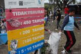 Pelajar bersama keluarganya menggotong karung berisi sampah di pantai di kawasan Jembatan Suramadu, Surabaya, Jawa Timur, Sabtu (1/11/2025). Sekitar 210 pelajar tingkat Sekolah Dasar dan Sekolah Menengah Pertama, keluarga dari pelajar, Komunitas Tunas Hijau dan petugas Dinas Lingkungan Hidup Kota Surabaya bergotong royong membersihkan pantai itu dari sampah agar pantai yang menjadi salah satu destinasi wisata tersebut terjaga kebersihannya. ANTARA Jatim/Didik Suhartono/mas.