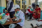 Petugas kesehatan Puskesmas Sukodono memberikan obat kepada warga terdampak banjir di Desa Kutorenon, Kecamatan Sukodono, Lumajang, Jawa Timur, Minggu (2/11/2025). Pemeriksaan meliputi pengecekan tekanan darah, kondisi kulit, dan saluran pernapasan serta pemberian obat-obatan dasar seperti vitamin, antipiretik, dan antibiotik ringan untuk mencegah penyakit pascabanjir. ANTARA Jatim/Irfan Sumanjaya/mas.