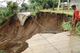 Warga nekat melihat kondisi jalan amblas terseret longsor di Desa Nyawangan, Tulungagung, Jawa Timur, Senin (3/11/2025). Jalan antardesa di lereng Gunung Wilis itu amblas terseret longsor di kedalaman 20 meter menyebabkan akses terganggu. Antara Jatim/Destyan Sujarwoko/um