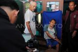 Petugas Dinas Kependudukan dan Pencatatan Sipil (Disdukcapil) Kota Bogor memotret warga penyandang disabilitas untuk perekaman data KTP elektronik saat Layanan Jempol Bahagia di Kampung Tegal Manggah, Kelurahan Tegallega, Kota Bogor, Jawa Barat, Kamis (30/10/2025). Layanan Jempol Bahagia merupakan program sistem jemput bola dari Disdukcapil Kota Bogor untuk pelayanan administrasi kependudukan terutama bagi penduduk rentan yang kesulitan mengakses layanan di kantor disdukcapil seperti lansia dan penderita sakit berat, disabilitas, serta orang dengan gangguan jiwa (ODGJ). ANTARA FOTO/Arif Firmansyah/nym. 