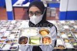 Pekerja menunjukkan menu Makanan Bergizi Gratis (MBG) hasil olahan Satuan Pelayanan Pemenuhan Gizi (SPPG) Polresta Samarinda di Samarinda Ulu Jawa, Kalimantan Timur, Selasa (4/11/2025). SPPG Polresta Samarinda saat ini mendistribusikan sebanyak 991 porsi MBG di tiga sekolah yakni SDN 007 Dadi Mulya, SDN 001, dan TK 15 di Kecamatan Samarinda Ulu. Antara Kaltim/M Risyal Hidayat
