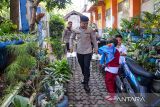 Anggota Polresta Bandung membawa Makanan Bergizi Gratis (MBG) untuk dibagikan kepada siswa di Sekolah Dasar Negeri Soreang 01 di Soreang, Kabupaten Bandung, Jawa Barat, Selasa (4/11/2025). SPPG Polresta Bandung mendistribusikan sebanyak 3.198 MBG ke 12 sekolah yang meliputi TK, SD, SMP dan SMA yang ada di Kecamatan Soreang. ANTARA FOTO/Raisan Al Farisi/agr