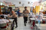 Anggota Polwan Polresta Bandung membagikan Makanan Bergizi Gratis (MBG) kepada siswa di Sekolah Dasar Negeri Soreang 01 di Soreang, Kabupaten Bandung, Jawa Barat, Selasa (4/11/2025). SPPG Polresta Bandung mendistribusikan sebanyak 3.198 MBG ke 12 sekolah yang meliputi TK, SD, SMP dan SMA yang ada di Kecamatan Soreang. ANTARA FOTO/Raisan Al Farisi/agr
