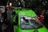 Warga mengamati mobil angkot yang ringsek di jalan raya Pajajaran, Kota Bogor, Jawa Barat, Senin (3/11/2025). Hujan deras disertai angin kencang di wilayah Kota Bogor mengakibatkan sebuah pohon besar yang sudah rapuh tumbang menimpa mobil angkot dan tidak ada korban jiwa dalam peristiwa tersebut. ANTARA FOTO/Arif Firmansyah/nz.