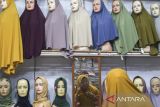 Pembeli mencoba kerudung di Pasar Kranggot, Kota Cilegon, Banten, Rabu (5/11/2025). Badan Pusat Statistik (BPS) Provinsi Banten mencatat pada Oktober 2025 secara tahunan, Banten mengalami inflasi sebesar 2,75 persen dengan Indeks Harga Konsumen (IHK) sebesar 108,51 yang disebabkan adanya kenaikan harga pada sembilan kelompok pengeluaran di antaranya kelompok makanan, minuman, dan tembakau sebesar 4,98 persen serta kelompok pakaian dan alas kaki sebesar 0,95 persen. ANTARA FOTO/Angga Budhiyanto/gp