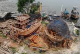 Foto udara pekerja membuat kapal nelayan tradisional di Brondong, Lamongan , Jawa Timur, Rabu (5/11/2025). Pembuatan kapal nelayan berkapasitas 30 - 40 ton yang dikerjakan secara tradisional itu menghabiskan waktu sekitar lima bulan hingga enam bulan tergantung ketersediaan bahan baku dengan biaya mencapai Rp1,5 miliar hingga Rp2 miliar per kapal. ANTARA Jatim/Muhammad Mada/mas.