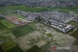 Foto udara kompleks perumahan di antara area persawahan di Sepatan, Kabupaten Tangerang, Banten, Kamis (6/11/2025). Presiden Prabowo Subianto mengatakan pemerintah mulai mencetak sawah baru seluas 225.000 hektare dan menargetkan total perluasan mencapai 480.000 hektare pada akhir tahun 2026 guna mengatasi sekitar 100.000 hektare lahan sawah di Indonesia yang hilang setiap tahunnya akibat alih fungsi menjadi kawasan perumahan, industri dan peruntukan lain. ANTARA FOTO/Putra M. Akbar/gp