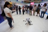 Pengunjung menyaksikan manuver robot anjing yang dikembangkan tim robotika Institut Teknologi Sepuluh Nopember (ITS) saat pameran teknologi dan inovasi (TennoveX) 2025 di Surabaya, Jawa Timur, Kamis (6/11/2025). Pameran yang diikuti sekitar 66 inovasi teknologi karya sivitas akademika ITS tersebut sebagai ajang promosi untuk menjawab kebutuhan masyarakat maupun industri sekaligus upaya mendukung kemandirian bangsa di bidang teknologi. ANTARA Jatim/Moch Asim.