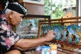 Seniman menyelesaikan lukisan tokoh pewayangan di atas media limbah kulit sisa bahan bedug di Jatimulyo, Tulungagung, Jawa Timur, Jumat (7/11/2025). Lukisan dengan media limbah kulit bedug itu dijual mulai Rp1,5 juta hingga Rp2,5 juta per buah dan dipasarkan secara daring. ANTARA Jatim/Destyan Sujarwoko/mas.