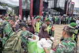 Prajurit TNI membagikan makan siang gratis bagi pengemudi ojek daring saat bakti sosial di Soreang, Kabupaten Bandung, Jawa Barat, Senin (10/11/2025). Pusat Kesenjataan Infanteri (Pussenif) menggelar bakti sosial dengan membagikan sedikitnya 8.000 paket sembako, makan siang gratis serta suku cadang motor gratis bagi masyarakat dan pengemudi ojek dalam rangka memperingati Hari Pahlawan. ANTARA FOTO/Abdan Syakura/agr