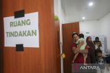Orang tua menggendong anaknya saat antre untuk dikhitan di Rumah Sehat Baznas, Kota Serang, Banten, Selasa (11/11/2025). Badan Amil Zakat Nasional (Baznas) Provinsi Banten menggelar khitanan massal gratis untuk kaum mustahik atau orang yang berhak menerima zakat dengan menyediakan sebanyak 100 kuota peserta. ANTARA FOTO/Angga Budhiyanto/gp