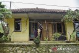 Warga memperlihatkan tembok rumah retak akibat pergerakan tanah di Desa Payung Agung, Kecamatan Panumbangan, Kabupaten Ciamis, Jawa Barat, Kamis (13/11/2025). Bencana pergerakan tanah di Dusun Pamekaran dan Limus Agung itu kini meluas dan mengakibatkan 49 rumah rusak serta 68 KK atau 191 jiwa mengungsi di Madrasah yang disediakan Pemerintah desa setempat. ANTARA FOTO/Adeng Bustomi/agr