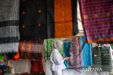 Pengunjung mengamati produk kain khas Majalaya Kabupaten Bandung saat mengunjungi pameran produk unggulan Jawa Barat pada ajang Jabar Kabisa di Sarana Olah Raga Arcamanik, Bandung, Jawa Barat, Kamis (13/11/2025). Pemerintah Provinsi Jawa Barat menggelar pameran produk unggulan seperti fesyen, kuliner, kerajinan dari berbagai kota yang ada di Jawa Barat yang ditujukan untuk memasarkan produk UMKM kepada masyarakat luas. ANTARA FOTO/Raisan Al Farisiagr