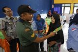 Anggota TNI memberikan hadiah hiburan kepada orang dengan gangguan jiwa (ODGJ) saat posyandu jiwa di kelurahan Tamanan, Kota Kediri, Jawa Timur, Kamis (13/11/2025). Posyandu jiwa yang diselenggarakan secara berkesinambungan oleh Dinas Sosial tersebut guna memantau kondisi kesehatan sekaligus memberikan layanan pengobatan kepada 24 ODGJ dari empat kelurahan se-Kota Kediri. ANTARA Jatim/Prasetia Fauzani/mas.