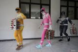 Sejumlah petugas berkostum Power Rangers mengantar Makan Bergizi Gratis (MBG) di SD Negeri Tempurejo 1, Kota Kediri, Jawa Timur, Kamis (13/11/2025). Petugas dari Satuan Pelayanan Pemenuhan Gizi (SPPG) Tempurejo tersebut mengenakan kostum unik sebagai upaya menghibur pelajar sekaligus sosialisasi pentingnya asupan gizi melalui MBG agar tubuh sehat dan kuat. ANTARA Jatim/Prasetia Fauzani/mas.