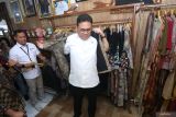 Menteri Perdagangan (Mendag) Budi Santoso mencoba pakaian berbahan kain ecoprint saat mengunjungi Namira Ecoprint di Surabaya, Jawa Timur, Kamis (13/11/2025). Kunjungan tersebut guna melihat secara langsung proses produksi ecoprint dan sebagai dukungan nyata pemerintah dalam meningkatkan daya saing produk UMKM agar dapat menembus pasar ekspor. ANTARA Jatim/Moch Asim.