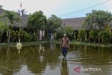Penjaga sekolah berkeliling mengecek banjir di area halaman SD Negeri Pamarican 2, Kota Serang, Banten, Kamis (13/11/2025). Sebanyak dua sekolah dasar di daerah tersebut terdampak banjir sejak Senin (10/11) akibat posisi sekolah yang lebih rendah dari jalan disertai buruknya saluran drainase sehingga mengakibatkan kegiatan belajar mengajar terpaksa dilaksanakan secara daring. ANTARA FOTO/Muhammad Bagus Khoirunas/gp