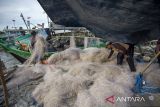 Nelayan memberbaiki jaring usai melaut di muara Karangsong, Indramayu, Jawa Barat, Jumat (14/11/2025). Pemerintah Kabupaten Indramayu menanggung penuh premi asuransi untuk 2.500 nelayan kecil dengan total nilai mencapai Rp504 juta dari APBD untuk melindungi dan memberikan rasa aman kepada nelayan dan keluarga mereka di rumah. ANTARA FOTO/Dedhez Anggara/agr
