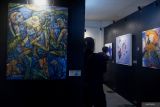 Pengunjung melihat karya seni rupa dalam pameran bertajuk 