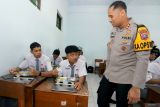 Kapolres Blitar Kota AKBP Titus Yudo Uly (kanan) berbincang dengan siswa penerima manfaat Makan Bergizi Gratis (MBG) dari Satuan Pelayanan Pemenuhan Gizi (SPPG) Polres Blitar Kota di SMK Islam 1 Kota Blitar, Jawa Timur, Senin (17/11/2025). Polres Blitar Kota mulai mensimulasikan pengolahan, pengantaran hingga pengujian keamanan pangan pada SPPG pertama milik Polri diwliyah tersebut, yang nantinya diharapkan mampu memenuhi kebutuhan gizi siswa dan warga sekitar. Antara Jatim/Irfan Anshori/um