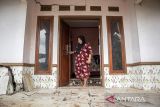 Warga berjalan di depan rumahnya yang rusak akibat pergerakan tanah di Kampung Gadung, Desa Cintaasih, Cipongkor, Kabupaten Bandung Barat, Jawa Barat, Senin (17/11/2025). Berdasarkan data BPBD Kabupaten Bandung Barat, sebanyak 32 rumah rusak ringan hingga berat dan 108 jiwa di tujuh kampung di Desa Cintaasih terdampak pergerakan tanah yang terjadi sejak tahun 2020. ANTARA FOTO/Abdan Syakura/agr