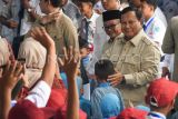 Presiden Prabowo Subianto (kanan) didampingi Menteri Pendidikan Dasar dan Menengah (Mendikdasmen) Abdul Mu'ti (kedua kanan) menyapa siswa-siswa sebelum meluncurkan program Digitalisasi Pembelajaran Untuk Indonesia Cerdas di SMP Negeri 4 Bekasi, Jawa Barat, Senin (17/11/2025). Berdasarkan data Kemendikdasmen per 16 November 2025, Pemerintah telah menyalurkan sebanyak 172.550 interaktif flat panel (IFP) atau papan interaktif digital (PID) ke berbagai sekolah dan Pusat Kegiatan Belajar Mengajar (PKBM) di Indonesia atau 75 persen dari target keseluruhan 288.865 IFP untuk tahun anggaran 2025 sebagai bagian dari program digitalisasi pembelajaran. ANTARA FOTO/Aditya Pradana Putra/foc.