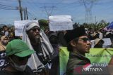 Pengunjuk rasa membawa poster saat mengikuti aksi memprotes operasional truk pengangkut tambang di Jalan Raya Bojonegara, Kabupaten Serang, Banten, Senin (17/11/2025). Aksi yang diikuti berbagai elemen masyarakat dan mahasiswa tersebut menuntut tindakan tegas dari pemerintah setempat terkait maraknya truk pengangkut tambang yang masih melanggar jam operasional karena dinilai menyebabkan kemacetan dan mengganggu aktivitas warga sekitar. ANTARA FOTO/Angga Budhiyanto/gp