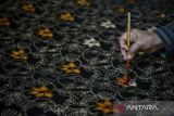 Perajin mewarnai kain batik di Rumah Batik Setu, Kota Tangerang Selatan, Banten, Selasa (18/11/2025). Menteri Usaha Mikro, Kecil dan Menengah (UMKM) Maman Abdurrahman menyatakan pemerintah meningkatkan plafon Kredit Usaha Rakyat (KUR) menjadi Rp320 triliun pada 2026 dan menghapus pembatasan frekuensi pengambilan pinjaman guna mencegah UMKM yang sedang tumbuh agar tidak mengalami kesulitan dalam mencari modal maupun mengembalikan pinjaman. ANTARA FOTO/Putra M. Akbar/gp
