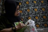 Perajin menorehkan lilin menggunakan canting saat membuat motif batik di Rumah Batik Setu, Kota Tangerang Selatan, Banten, Selasa (18/11/2025). Menteri Usaha Mikro, Kecil dan Menengah (UMKM) Maman Abdurrahman menyatakan pemerintah meningkatkan plafon Kredit Usaha Rakyat (KUR) menjadi Rp320 triliun pada 2026 dan menghapus pembatasan frekuensi pengambilan pinjaman guna mencegah UMKM yang sedang tumbuh agar tidak mengalami kesulitan dalam mencari modal maupun mengembalikan pinjaman. ANTARA FOTO/Putra M. Akbar/gp