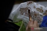 Perajin menorehkan lilin menggunakan canting saat membuat motif batik di Rumah Batik Setu, Kota Tangerang Selatan, Banten, Selasa (18/11/2025). Menteri Usaha Mikro, Kecil dan Menengah (UMKM) Maman Abdurrahman menyatakan pemerintah meningkatkan plafon Kredit Usaha Rakyat (KUR) menjadi Rp320 triliun pada 2026 dan menghapus pembatasan frekuensi pengambilan pinjaman guna mencegah UMKM yang sedang tumbuh agar tidak mengalami kesulitan dalam mencari modal maupun mengembalikan pinjaman. ANTARA FOTO/Putra M. Akbar/gp