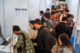 Pencari kerja mencari informasi di salah satu stan perusahaan pada pameran bursa kerja di Kiara Artha Park, Bandung, Jawa Barat, Rabu (19/11/2025). Pemerintah Kota Bandung melalui Disnakertrans Kota Bandung menggelar pameran bursa kerja yang menghadirkan 3.551 lowongan kerja dalam negeri, 6.702 lowongan kerja luar negeri dari 42 perusahaan yang ditujukan untuk pemenuhan lapangan kerja profesional di Kota Bandung. ANTARA FOTO/Raisan Al Farisi/agr