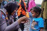 Tim Trauma Healing Srikandi Semeru Polres Lumajang memberikan makanan ringan kepada anak-anak pengungsi di Posko Pengungsian SDN 04 Supiturang, Pronojiwo, Lumajang, Jawa Timur, Jumat (21/11/2025). Kegiatan pendampingan pemulihan psikologis tersebut dilakukan untuk membantu anak-anak mengurangi rasa takut dan stres pasca bencana. Antara Jatim/Irfan Sumanjaya/um