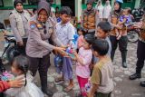 Tim Trauma Healing Srikandi Semeru Polres Lumajang memberikan hadiah kepada anak-anak pengungsi di Posko Pengungsian SDN 04 Supiturang, Pronojiwo, Lumajang, Jawa Timur, Jumat (21/11/2025). Kegiatan pendampingan pemulihan psikologis tersebut dilakukan untuk membantu anak-anak mengurangi rasa takut dan stres pasca bencana. Antara Jatim/Irfan Sumanjaya/um