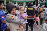 Tim Trauma Healing Srikandi Semeru Polres Lumajang menggendong anak saat bermain bersama anak-anak pengungsi di Posko Pengungsian SDN 04 Supiturang, Pronojiwo, Lumajang, Jawa Timur, Jumat (21/11/2025). Kegiatan pendampingan pemulihan psikologis tersebut dilakukan untuk membantu anak-anak mengurangi rasa takut dan stres pasca bencana. Antara Jatim/Irfan Sumanjaya/um
