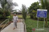 Pengurus lembaga adat Mapur Johan berjalan di gerbang pintu masuk rumah adat tradisional di Kampung Adat Gebong Memarong di Dusun Air Abik, Kabupaten Bangka, Bangka Belitung, Jumat (17/10/2025). ANTARA NEWS MALUKU/Andri Saputra/IWY