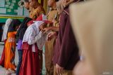 Murid bersalaman dengan guru sebelum mengikuti pembelajaran di SD Negeri 01 Supiturang, Pronojiwo, Lumajang, Jawa Timur, Senin (24/11/2025). Sekolah tersebut menampung total 289 siswa dari SDN 04 Supiturang yang masih difungsikan sebagai lokasi pengungsian dan SDN 02 Supiturang yang rusak akibat terdampak erupsi Gunung Semeru. ANTARA Jatim/Irfan Sumanjaya/mas.