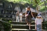 Wisatawan mancanegara berjalan di area situs arkeologi kuno saat berkunjung pada acara cerita di balik sejarah di Daya Tarik Wisata (DTW) Gunung Kawi, Gianyar, Bali, Selasa (25/11/2025). Kegiatan yang digelar Balai Pelestarian Kebudayaan Wilayah XV tersebut untuk mengenali peninggalan kebudayaan dan sejarah Bali yakni situs arkeologi kuno berupa kompleks candi yang dipahat di dinding tebing. ANTARA FOTO/Nyoman Hendra Wibowo/wsj.